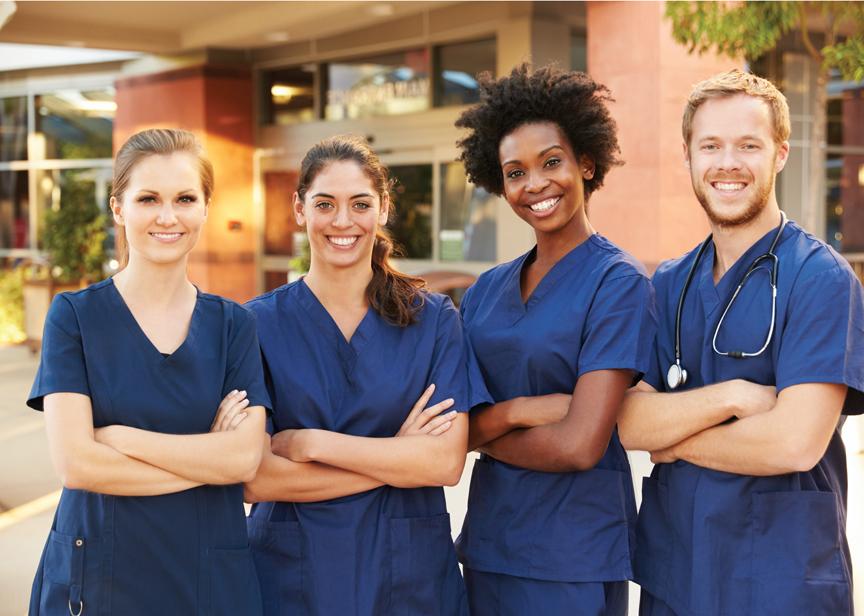 A team of nurses posing in front of their clinic